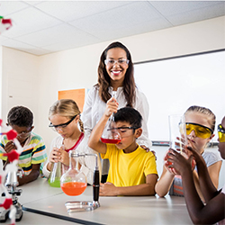 Teacher with group of students performing a chemistry experiment.