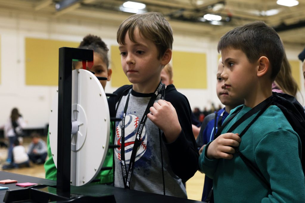 Two schoolage children spinning a wheel to explore career choices.