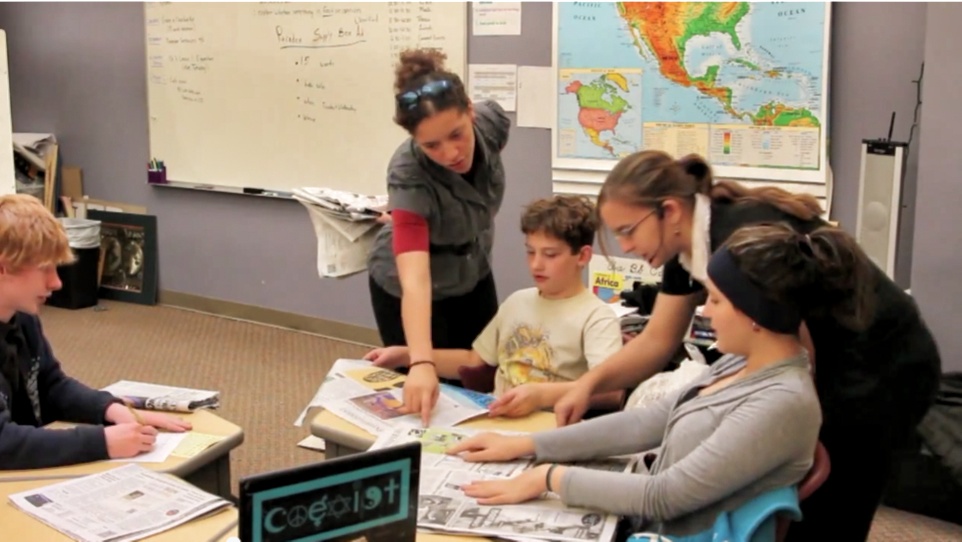 Student teacher helping students with worksheet.