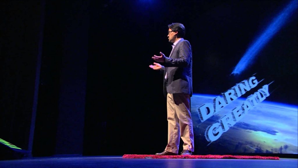 Bill Watson speaking on an auditorium stage