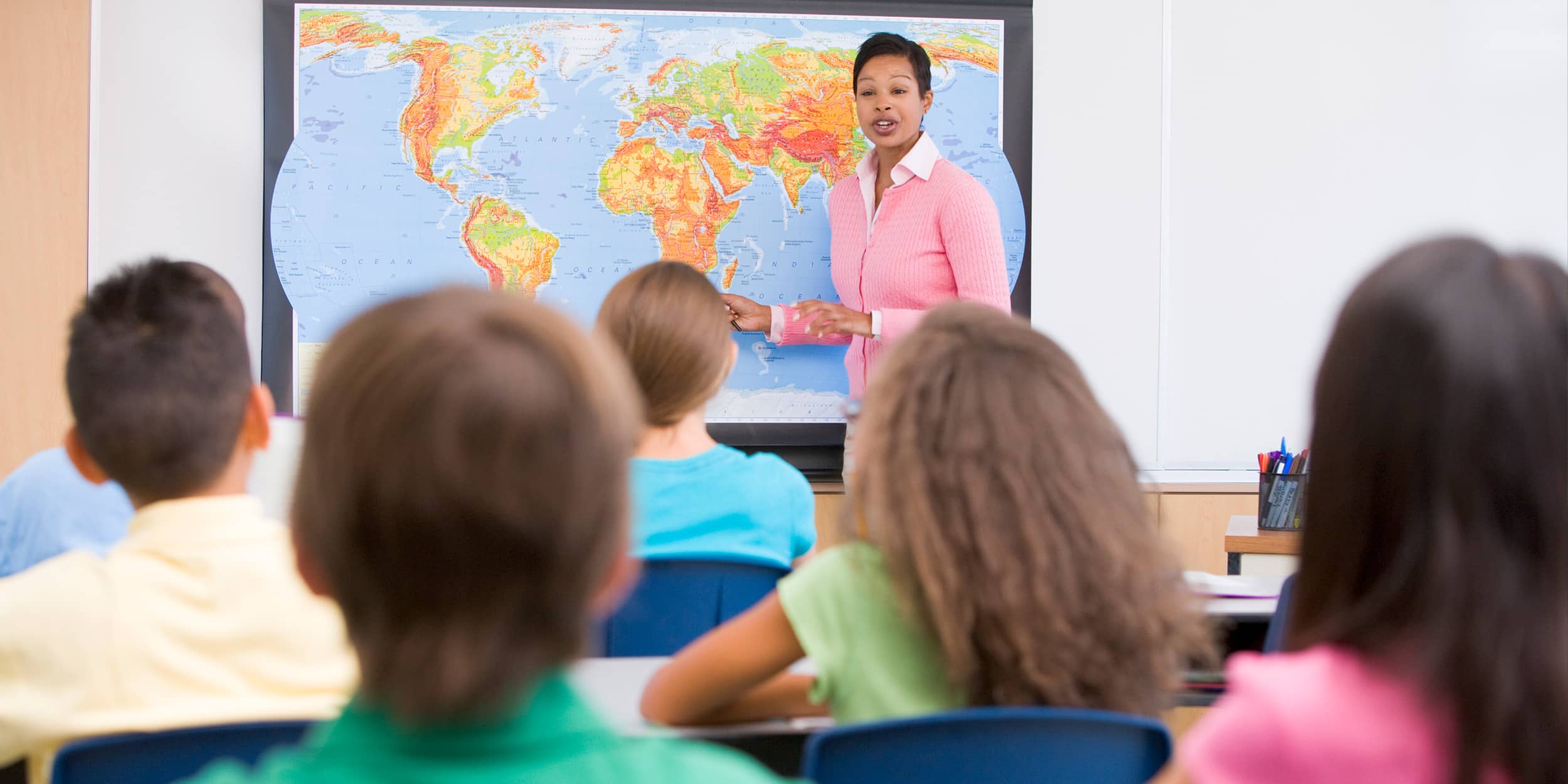 Elementary school teacher with pupils in geography class