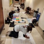 Students work on anchor charts in a hallway at Purdue University