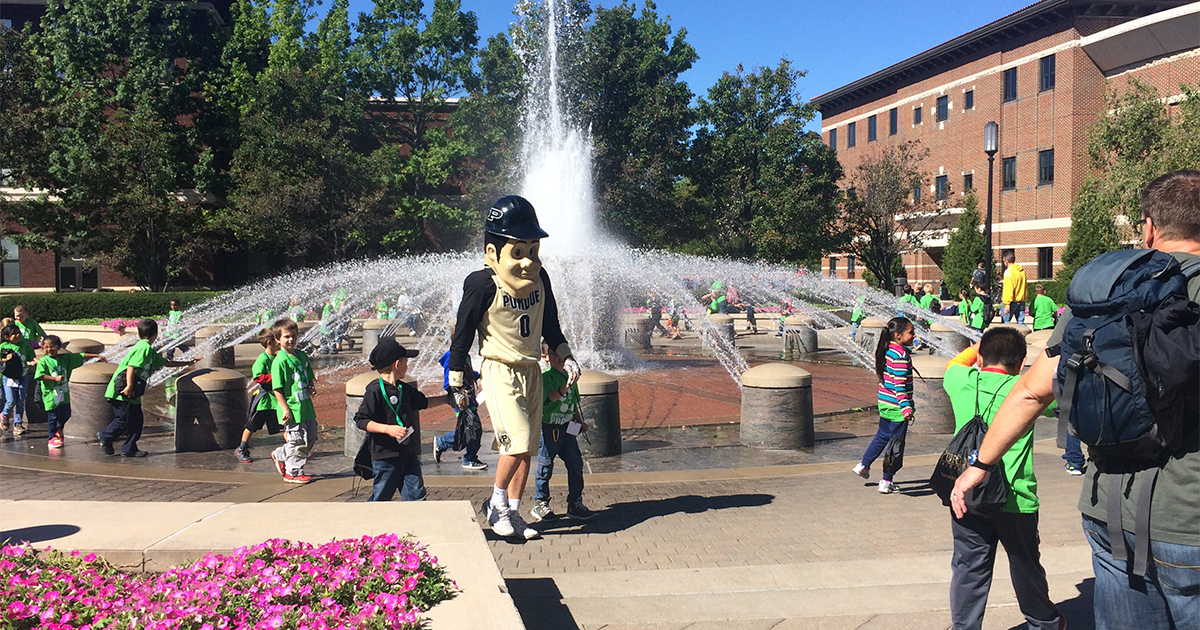 Purdue Pete escorts Indiana Promise students past the Beering Fountain and Beering Hall, the home of Purdue’s College of Education, during a past Indiana Promise campus visit. (Photo: Purdue University)