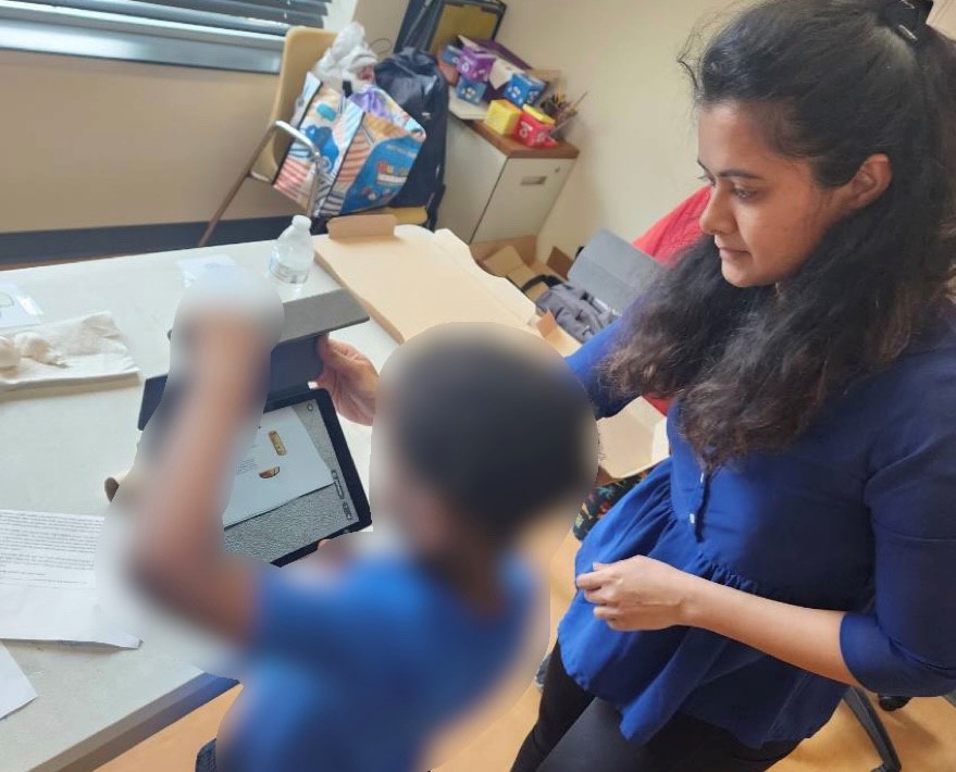 Deepti Tagare guides a young learner as he engages in an AR-based 
waste sorting activity using an iPad. 