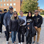 Interim Dean Phillip J. VanFossen with a College of Education student and their family smiling for a photo outside of Beering Hall
