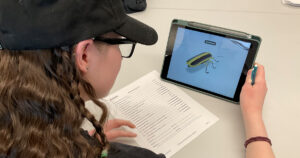 Science student examining 3D Insect image using AR application on an iPad