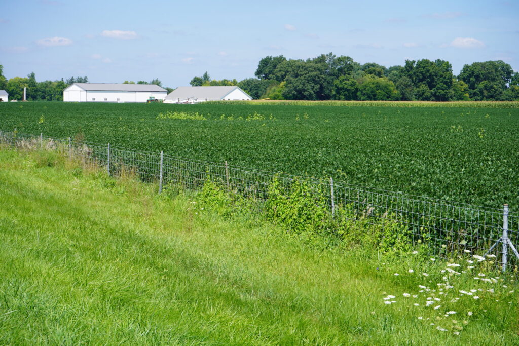 Rural Education Center outdoor shot with green fields and steel fencing.