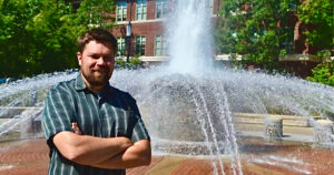 Ben Lathrop with his arms crossed in front of Beering Fountain