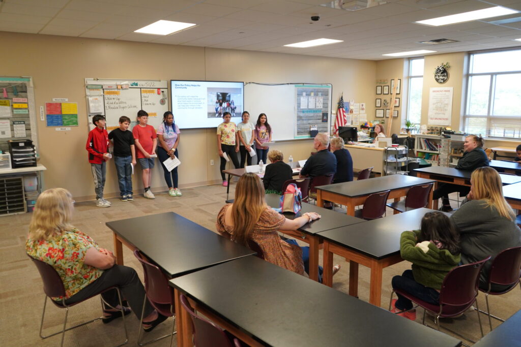 Middle school students present their project, "Reducing Food Waste at School", to judges and parents.