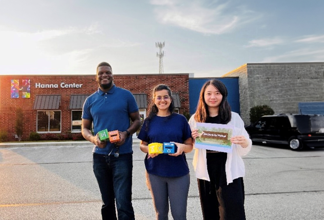 A group of three students standing outside the Hanna center.