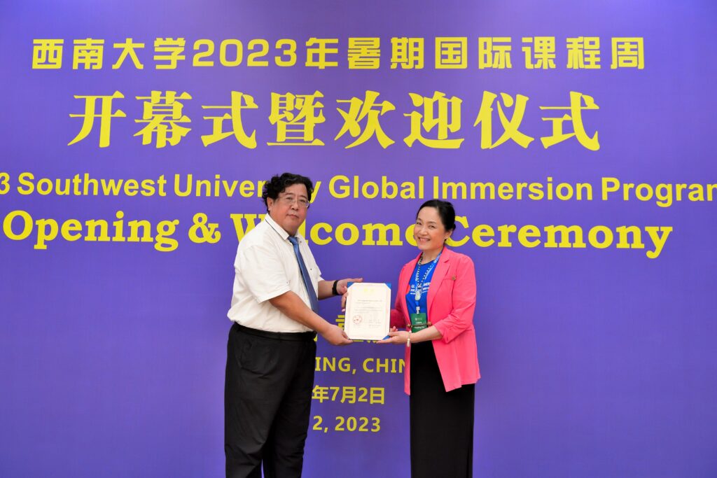 SWU’s vice president Yanqiang Cui (left) presents Xin (right) with a Letter of Appointment for teaching 
at the Global Immersion  program