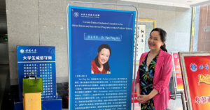 Xin beside a poster announcing her research talk at SWU’s Global Immersion Program