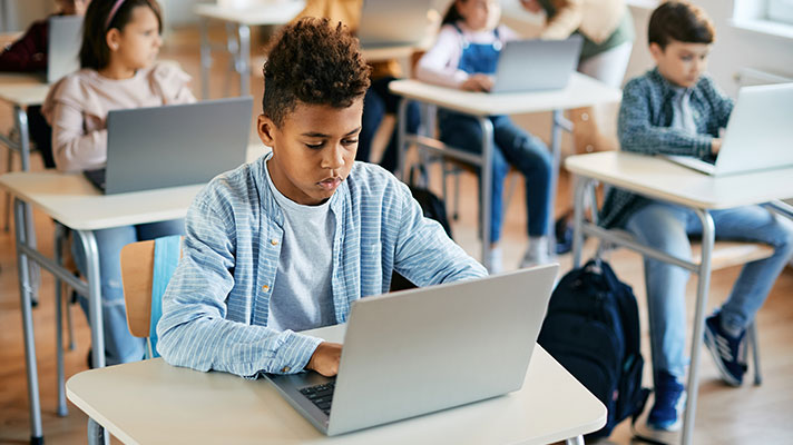 A student works on a laptop in a classroom