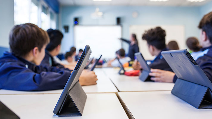 Students work on tablets in a classroom