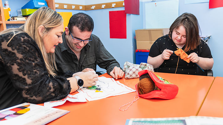 A teacher works with two special education students