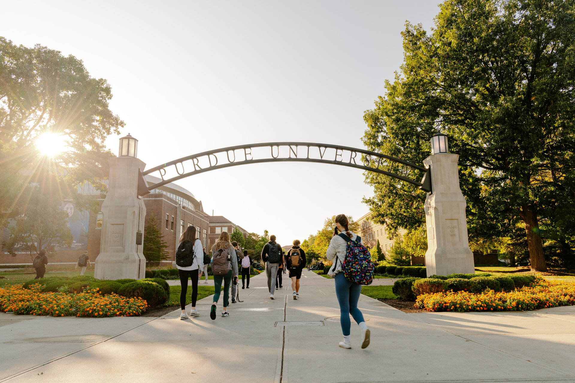 Students walk under the "Purdue University" arch