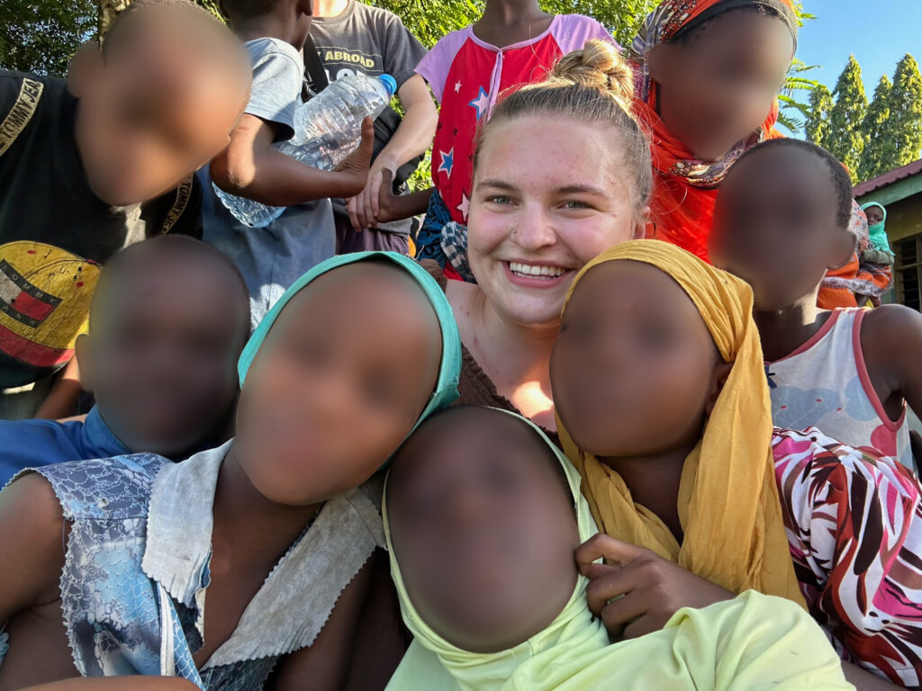 Bronwyn taking a selfie with a group of Tanzanian children.