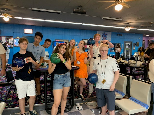A group of BFTF students in a bowling alley. Each are holding a bowling ball.