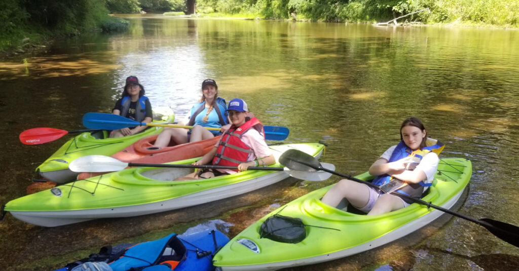Four BFTF students kayaking in a swampy area.