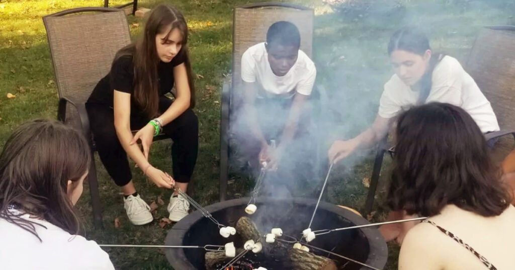 BFTF students making s'mores outside