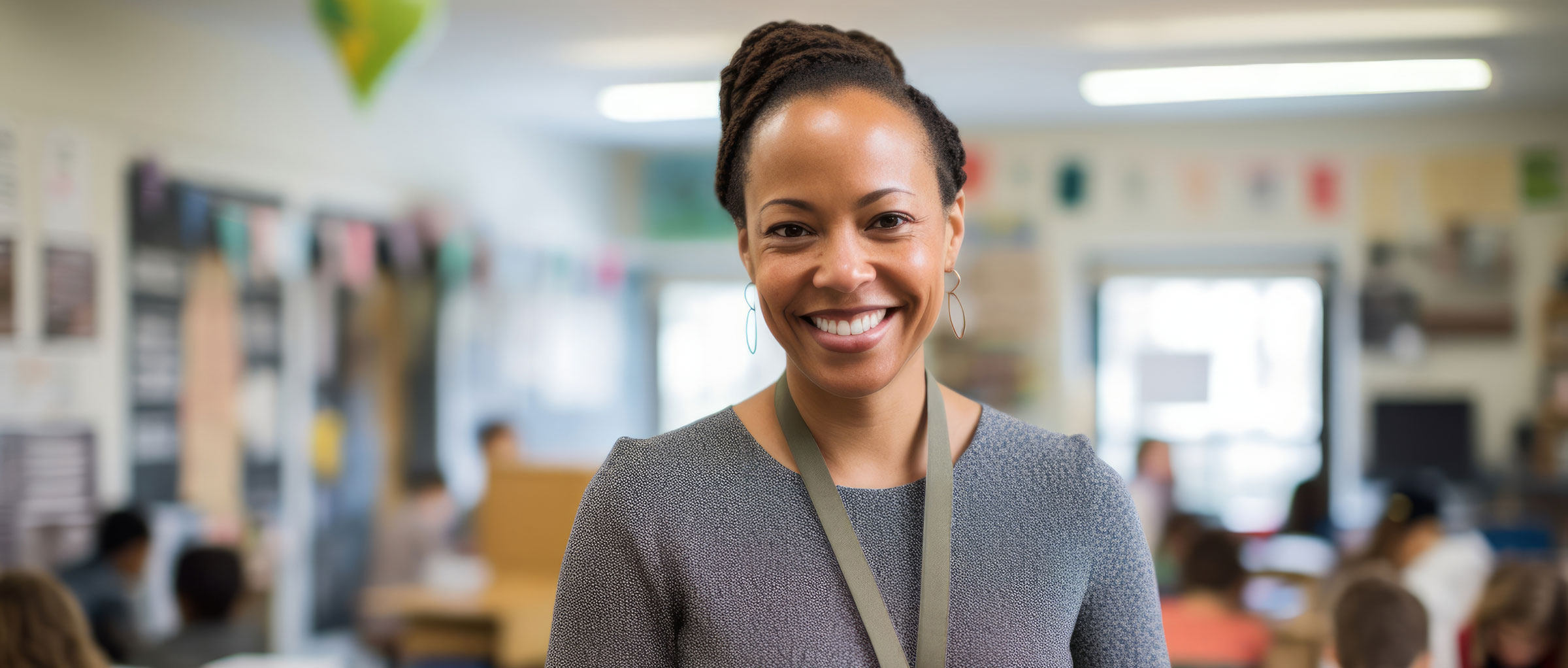 A black female teacher stands in a classroom.