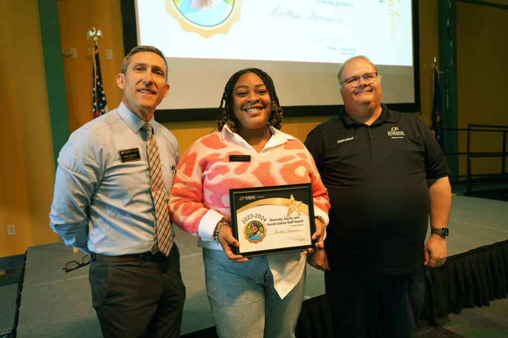 Brittne Paramore holding a certificate for the Diversity, Equity, and Social Justice Award for Faculty and Staff. Beside her are Interim Dean VanFossen and Wayne Wright