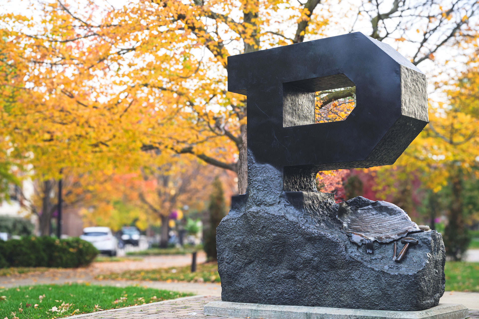 A "P" statue for Purdue University is seen in the foreground with yellow trees in the background.