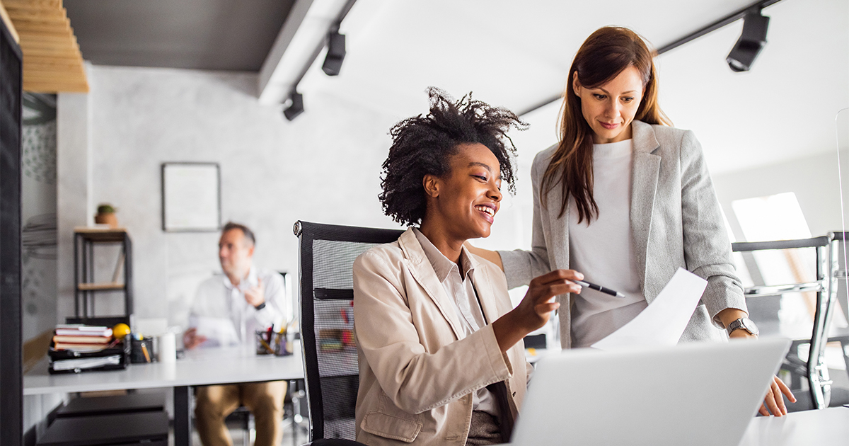 Two co-workers collaborating on a project in an office.