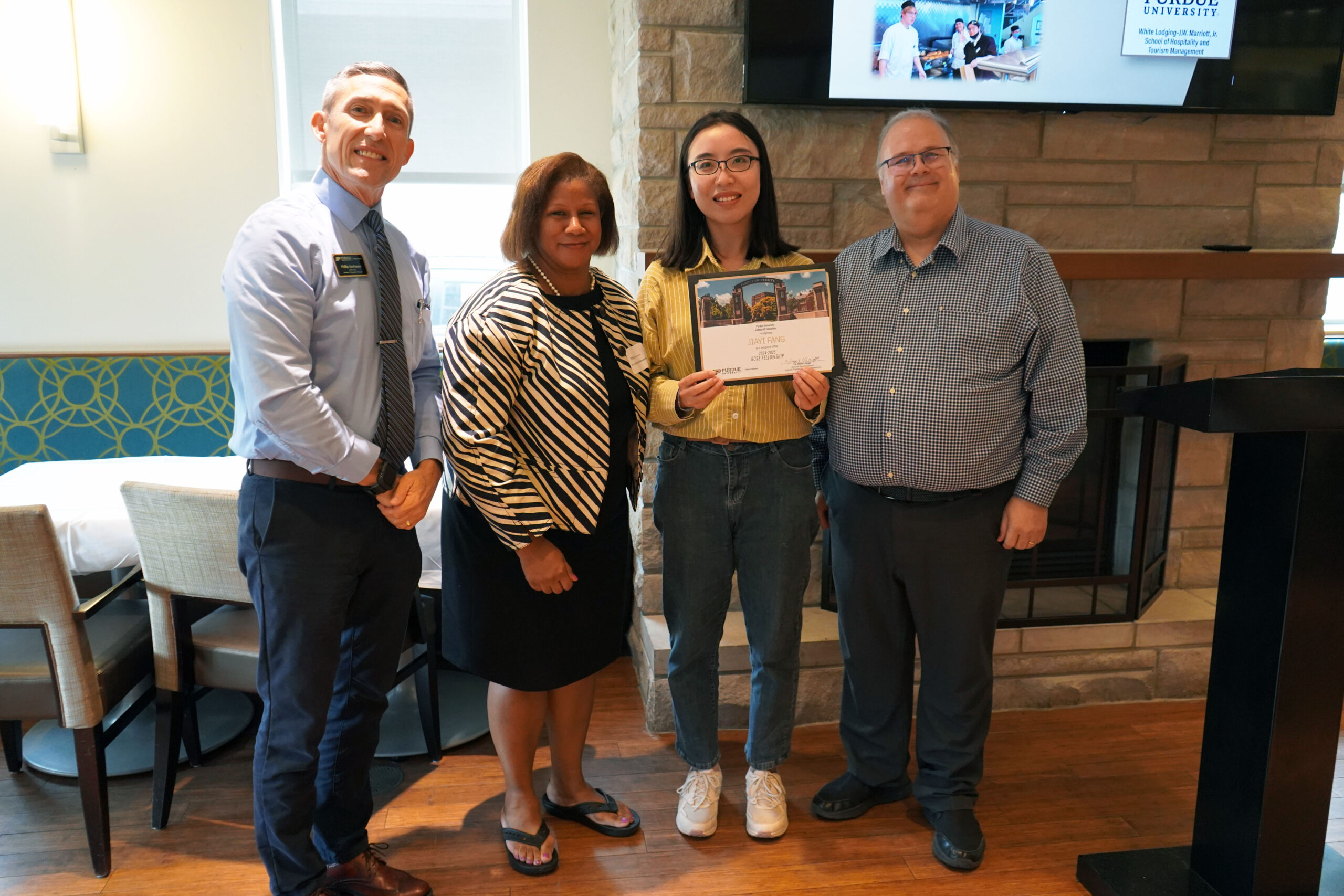 Jiayi Fang holding a certificate. Surrounding her are interim dean Phillip J. VanFossen, Dr. Chrystal Johnson, and Dr. Wayne Wright.