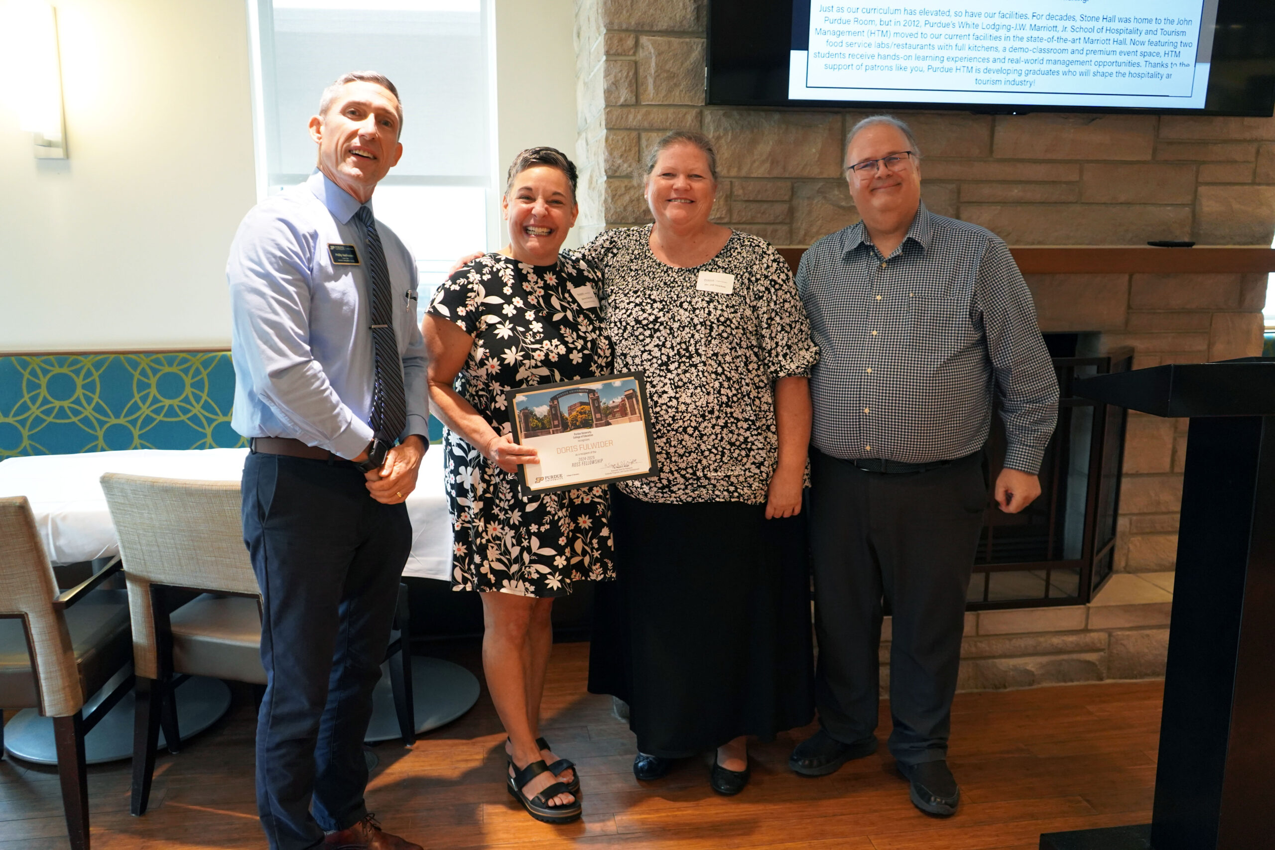 Doris Fulwider holding a certificate. Surrounding her are interim dean Phillip J. VanFossen, Dr. Jill Newton, and Dr. Wayne Wright.