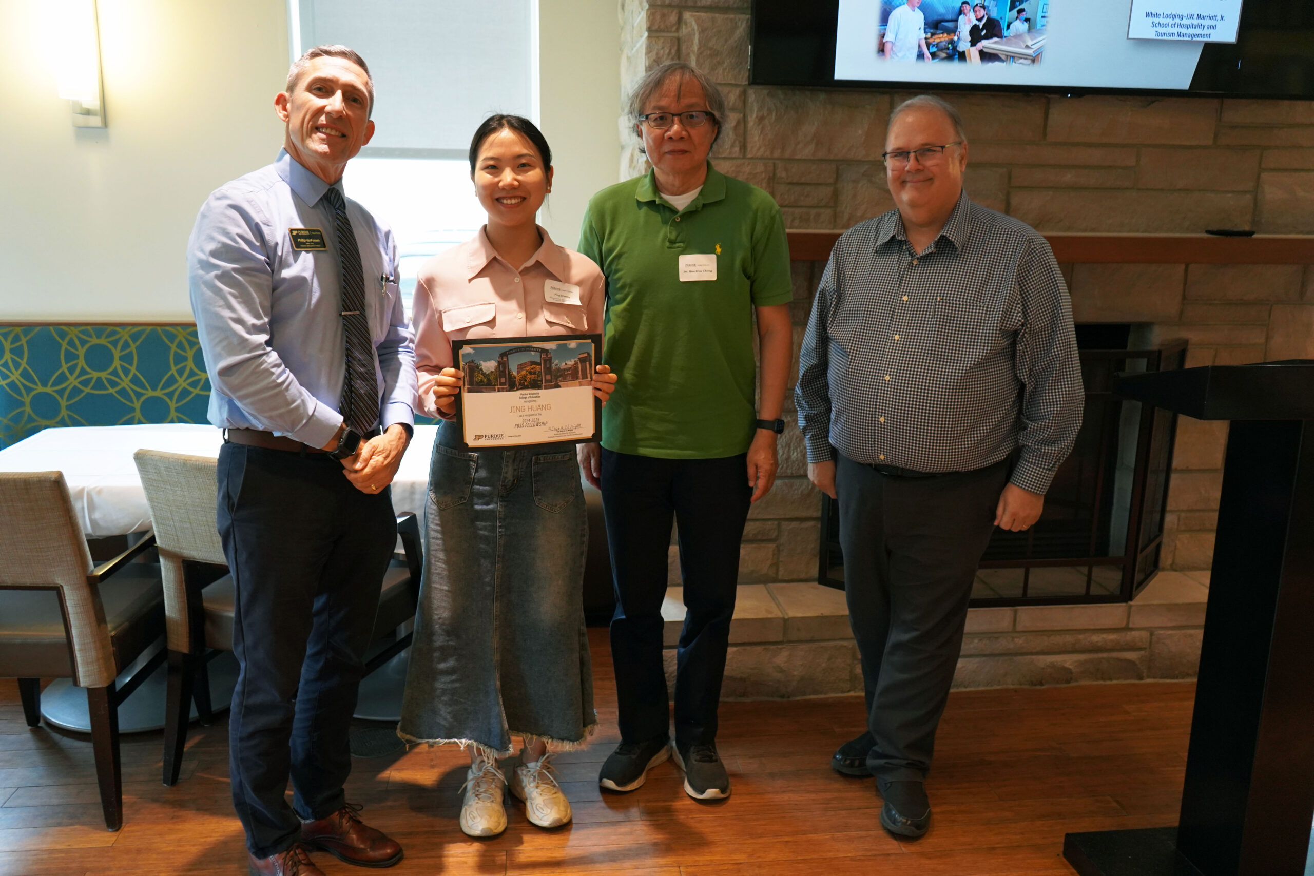 Jing Huang holding a certificate. Surrounding her are interim dean Phillip J. VanFossen, Dr. Hua Hua Chang, and Dr. Wayne Wright.