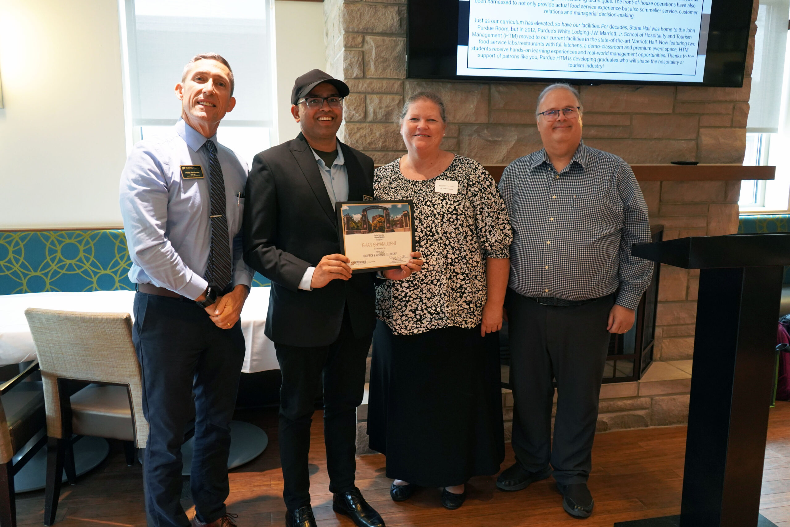 Ghan Shyam Joshi holding a certificate. Surrounding him are interim dean Phillip J. VanFossen, Dr. Jill Newton, and Dr. Wayne Wright.