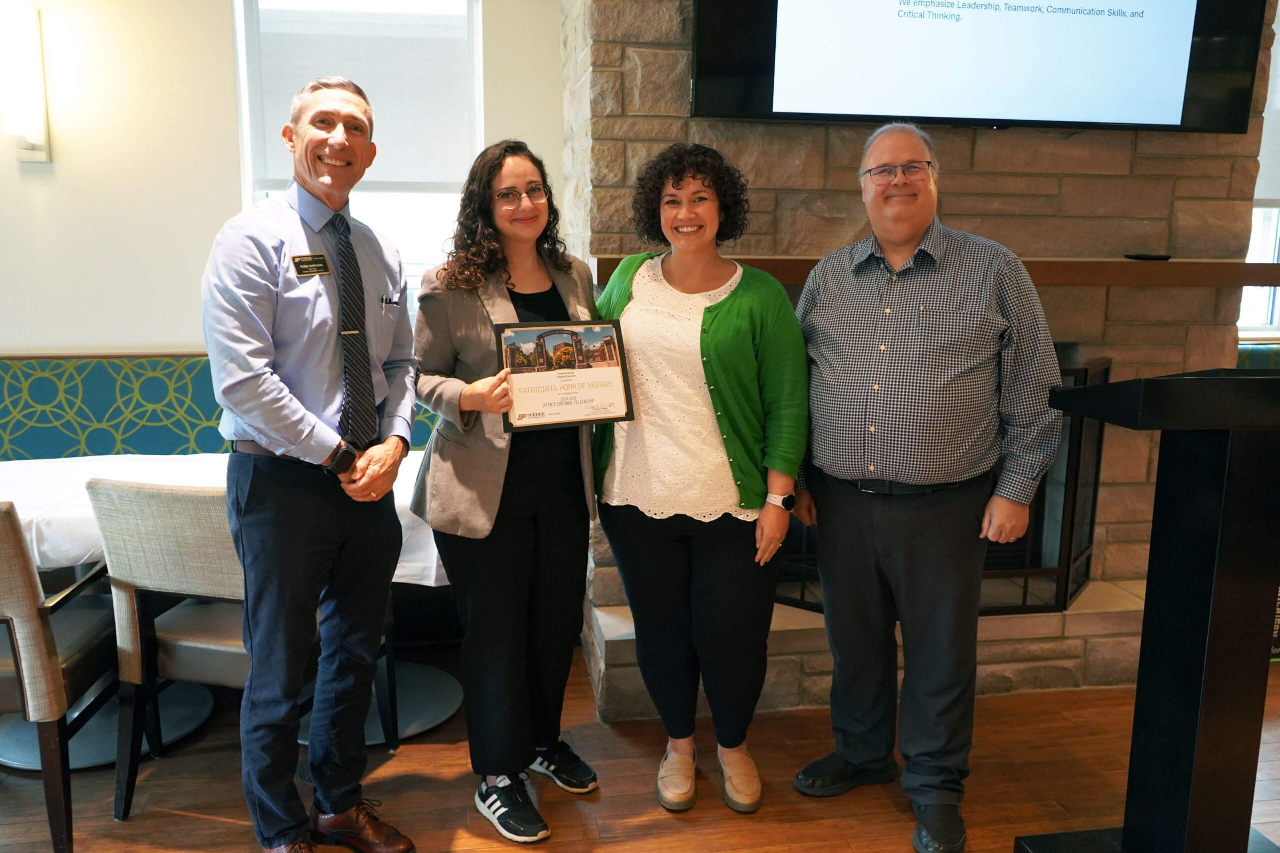 Patricia El Horr de Moraes holding a certificate. Surrounding her are interim dean Phillip J. VanFossen, Dr. Juliana Aguilar, and Dr. Wayne Wright.