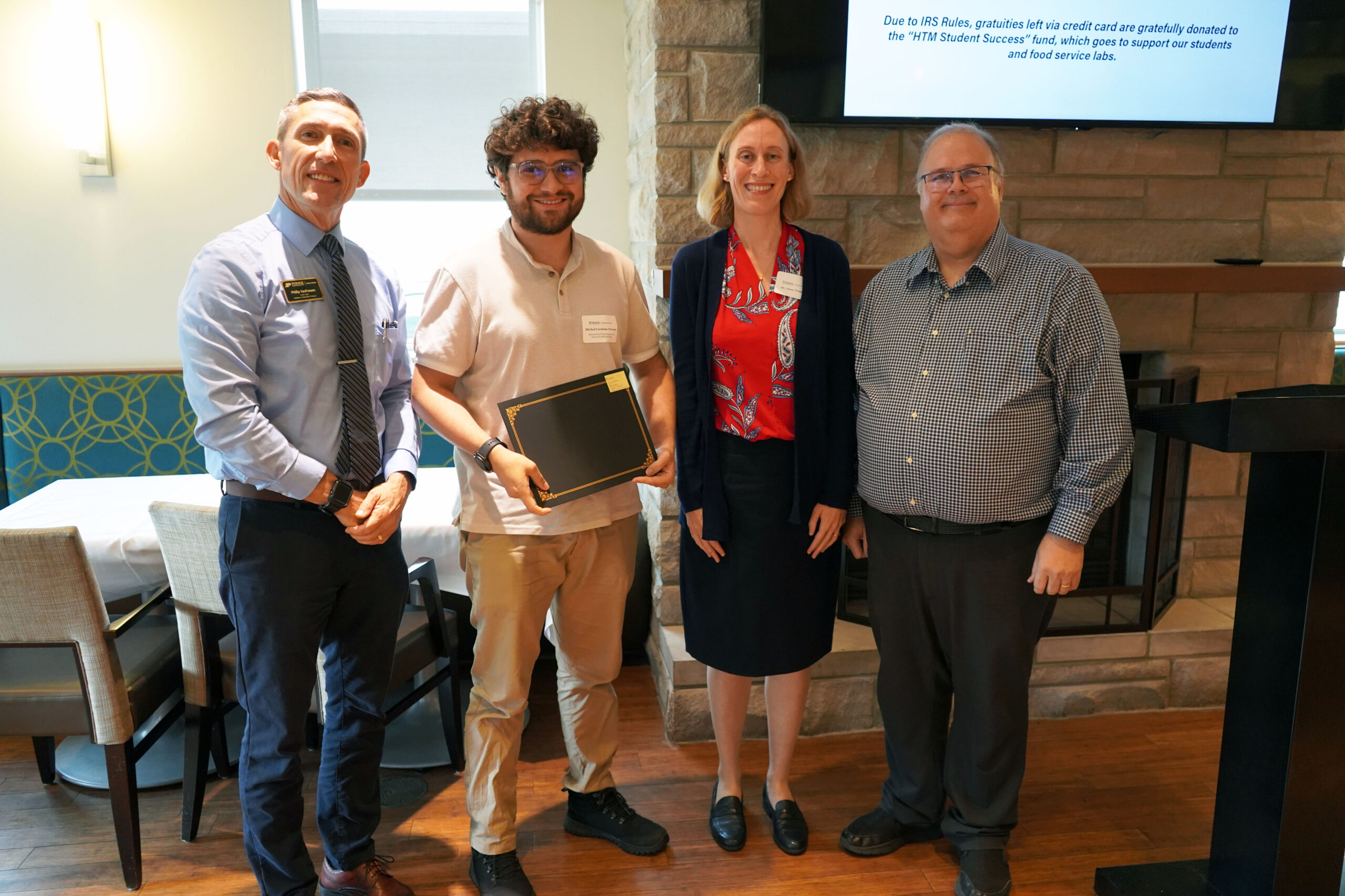 Michel Cordoba Perozo holding a certificate. Surrounding him are interim dean Phillip J. VanFossen, Dr. Wayne Wright, and Dr. Anne Traynor.