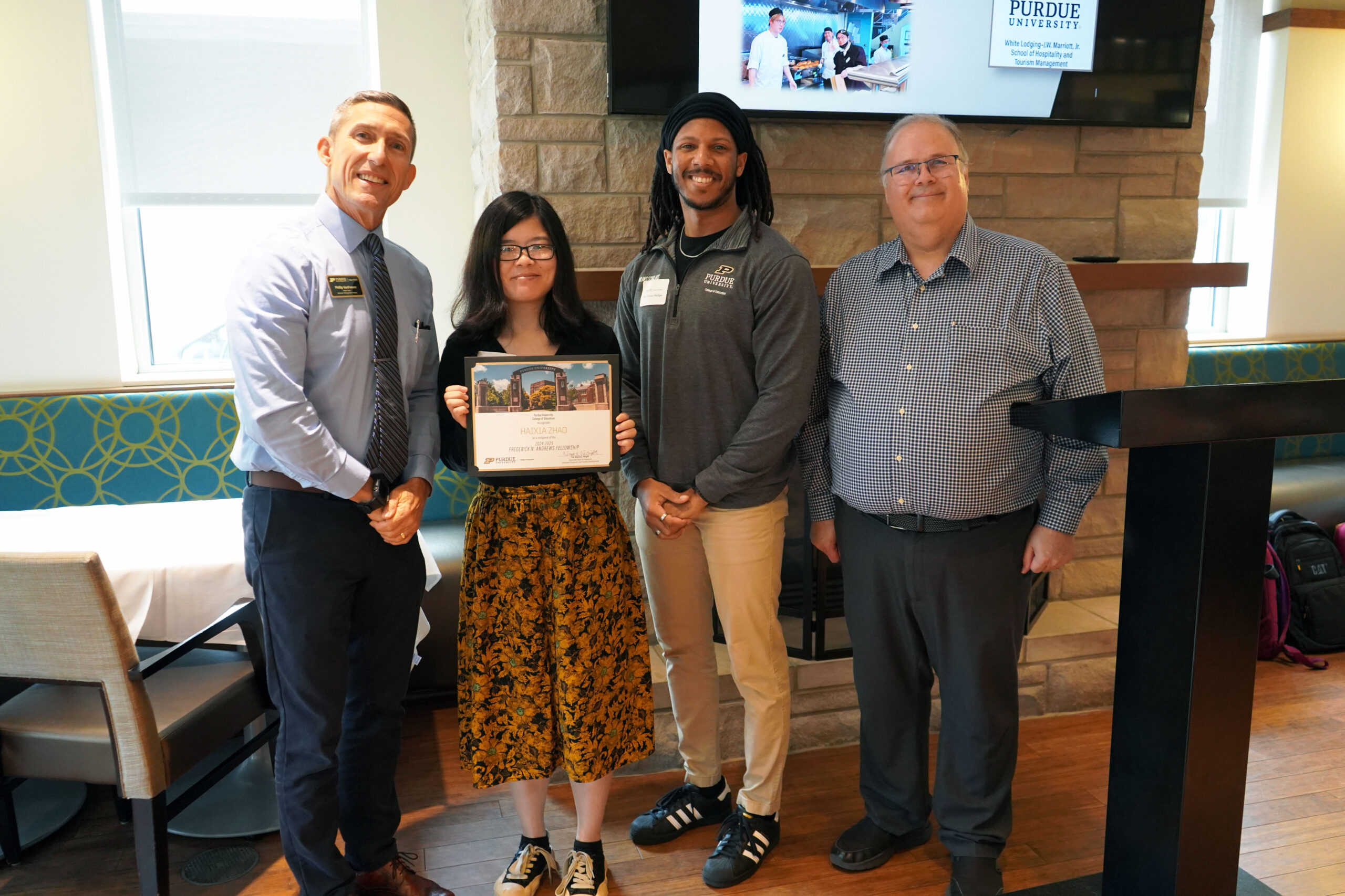 Haixia Zhao holding a certificate. Surrounding her are interim dean Phillip J. VanFossen, Dr. Terron Phillips, and Dr. Wayne Wright.