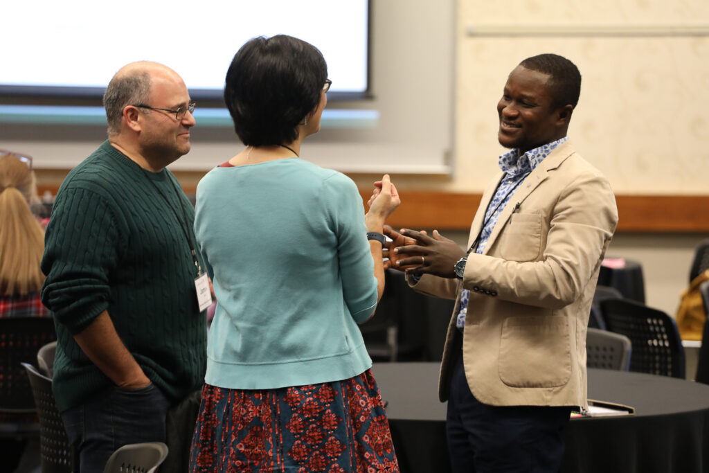 Trish Morita-Mullaney, James Cohen, and Razak Dwomoh networking together.