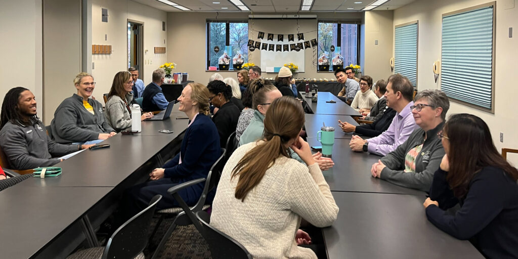 EDST faculty sitting at a table and socializing.