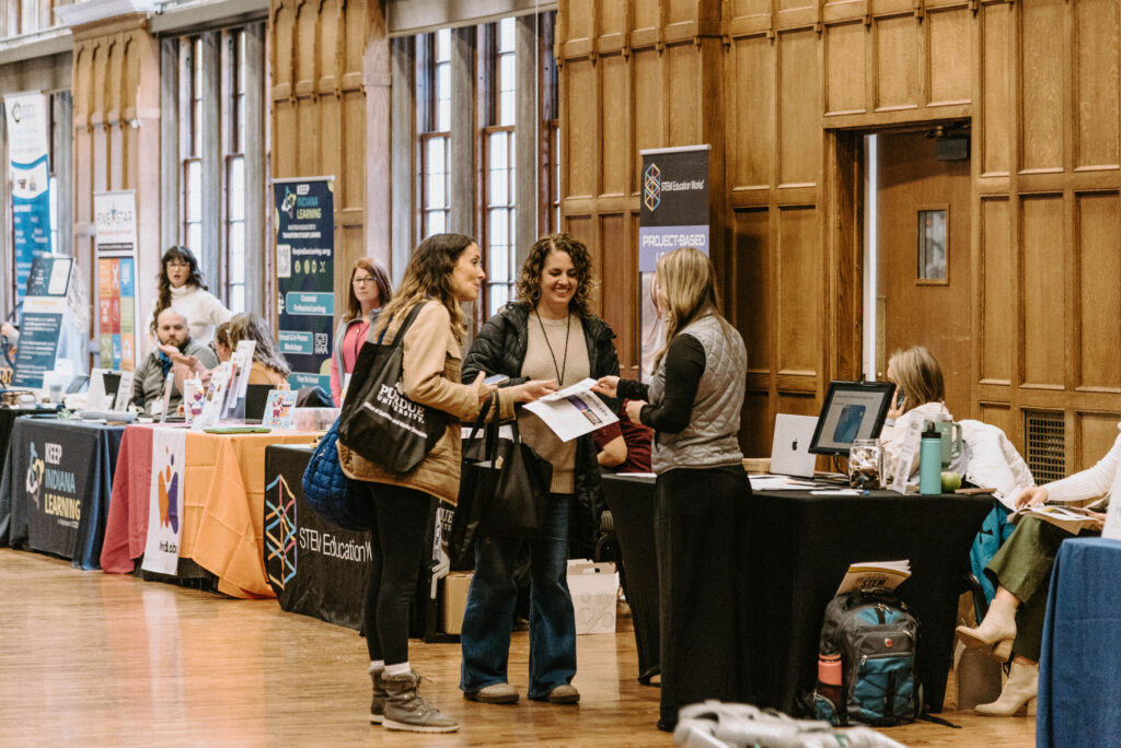 Conference attendees chatting with each other in the exhibit hall.