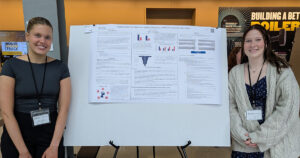 URT Program students Jessica Wallace and Leah Miles standing besides their research poster.