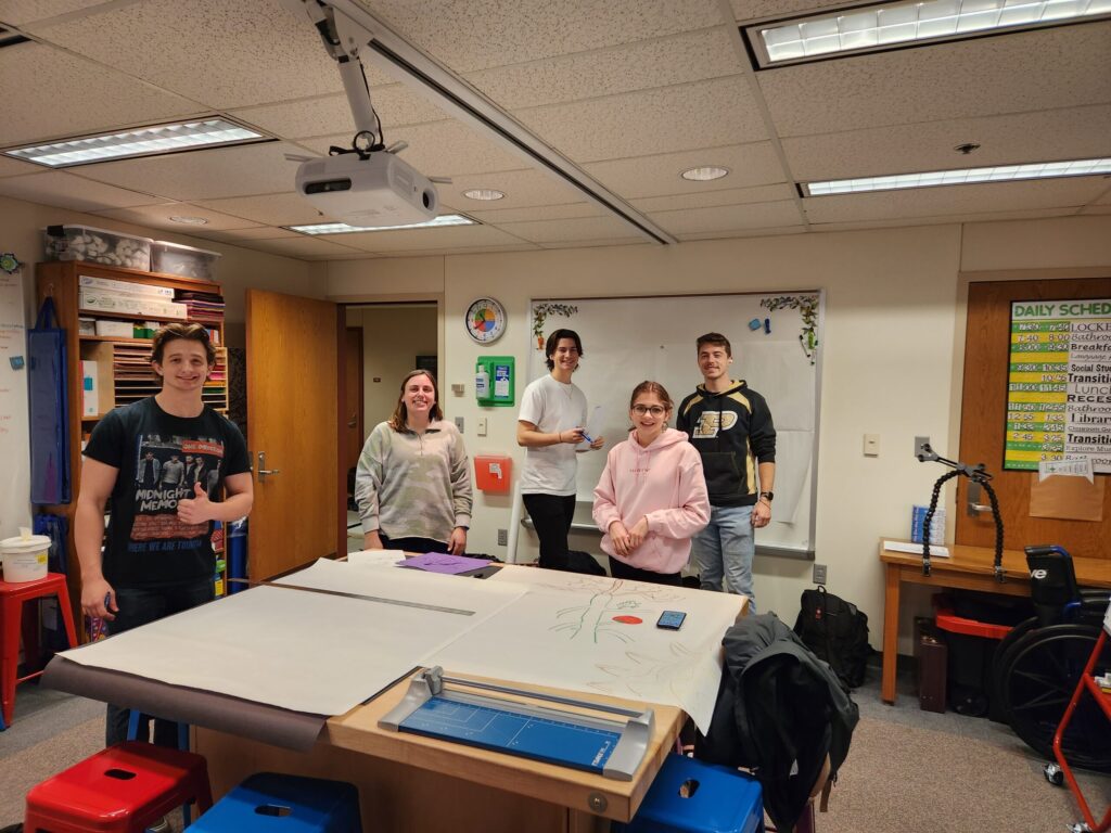A group of students stand around a table in the Action Lab at CREATE at Purdue University