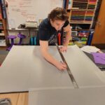 A student works on an Anchor chart at CREATE