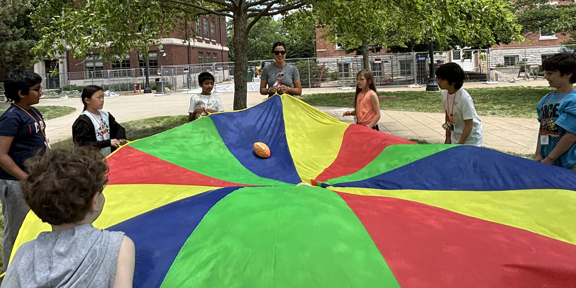 GER2I Summer Residential campers play outside with a parachute.