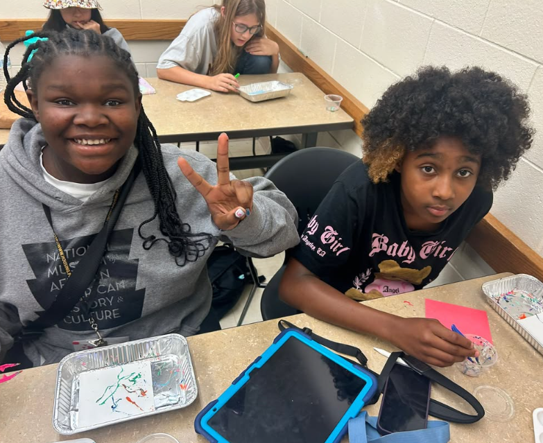 Two black students work on projects in a classroom