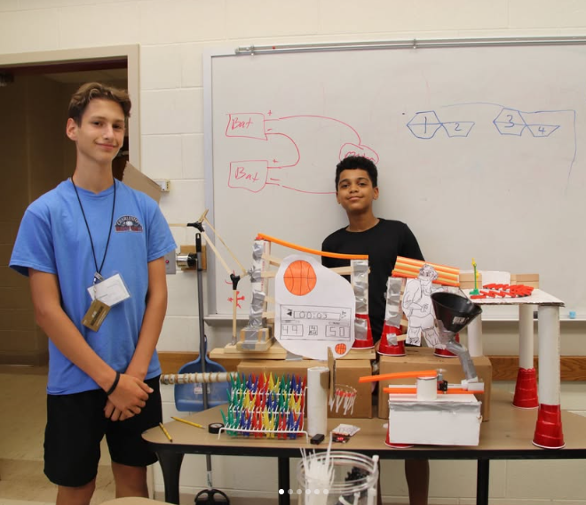 Two GER2I students stand with their project