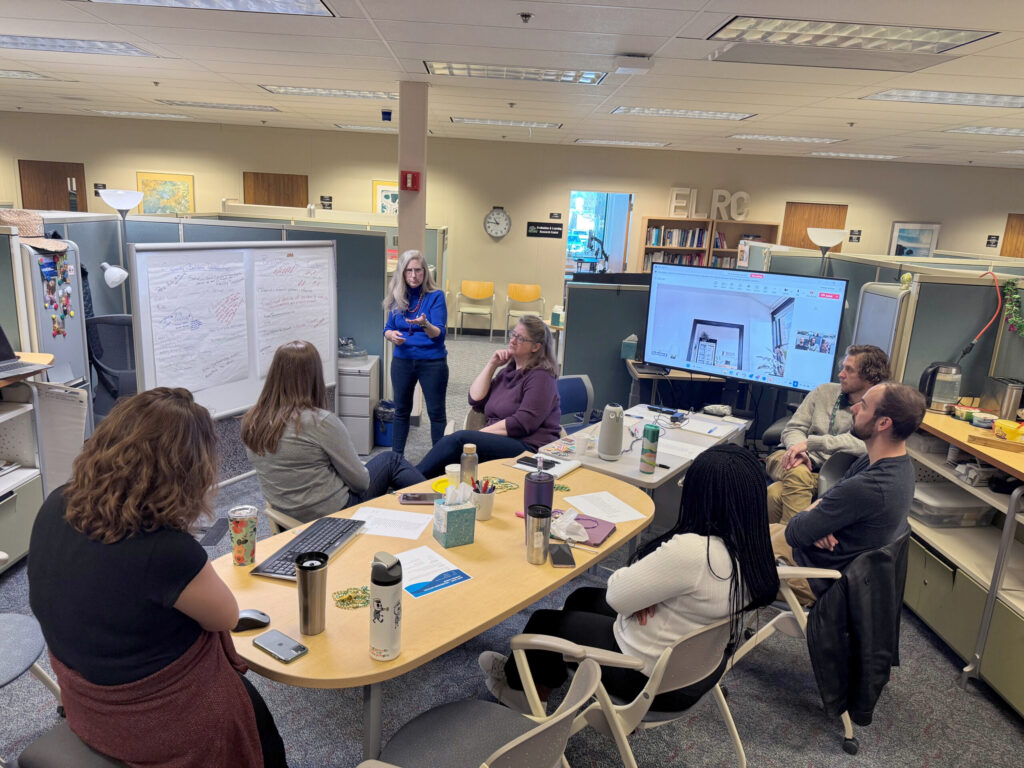 ELRC staff seated at a table. Dr. Willie Burgess is standing at a whiteboard.