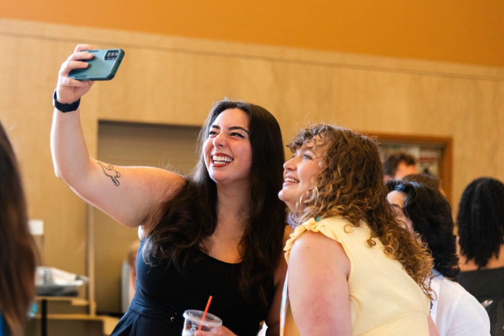 Two young women taking a selfie in the Loeb Playhouse lobby.