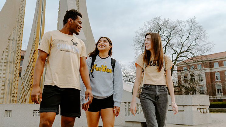 Three Purdue students walking in front of Engineering Fountain.