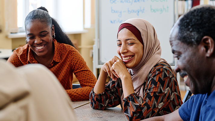 Students sit around a table during a lesson.