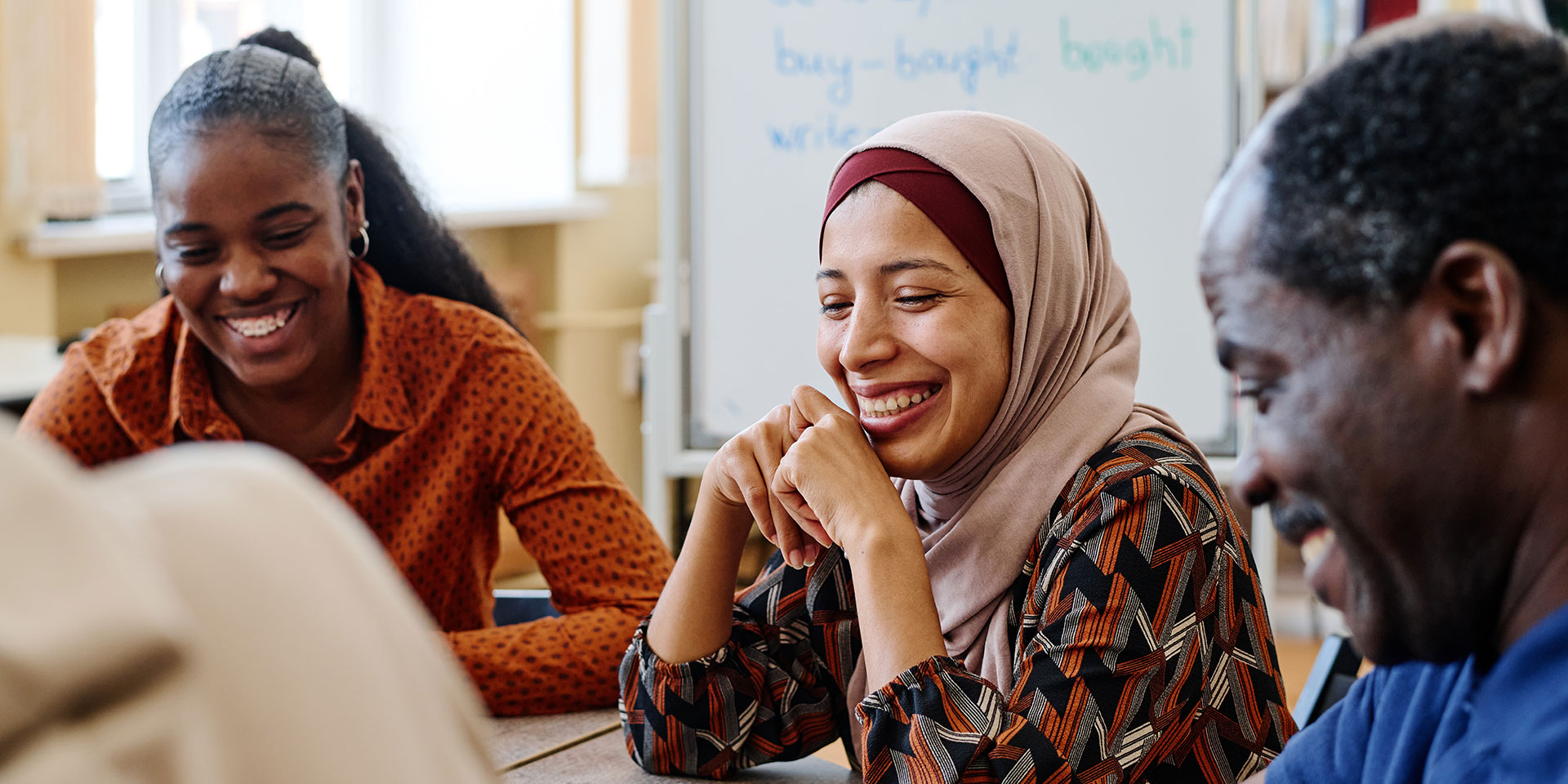 Students sit around a table during a lesson.
