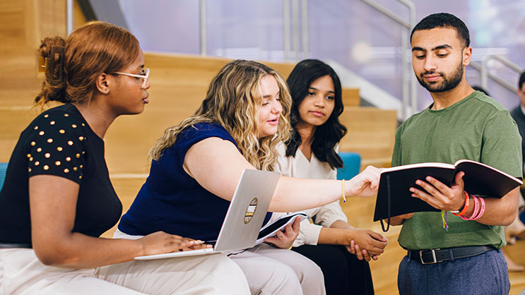 A group of young adults working together in a classroom.